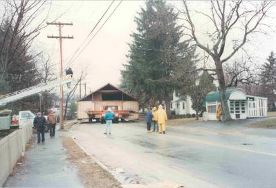 people standing near a wooden structure on a truck in the street