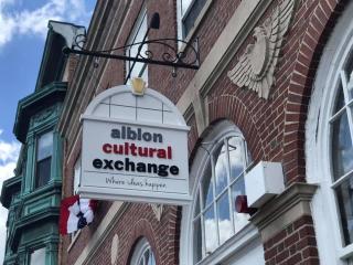 sign hanging from brick building that reads albion cultural exchange