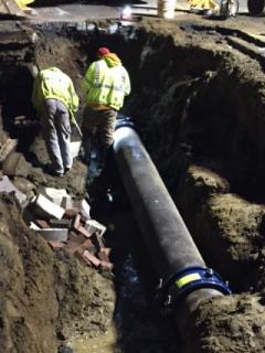 Water main in the ground with two employees